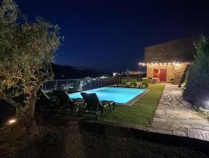 a swimming pool at night with chairs around it at Quinta do Fraguil - Douro Valley in Valença do Douro