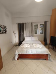 a bedroom with a bed with two towels on it at Cozy apartment in the center of Aighion Achaia - ground floor - ισόγειο στουντιο in Aigio