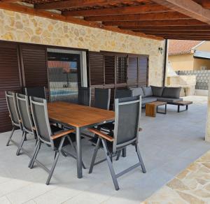 a wooden table and chairs on a patio at Vila Brod in Šibenik