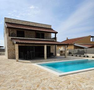 a house with a swimming pool in front of it at Vila Brod in Šibenik