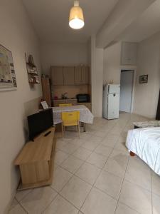 a living room with a table and a kitchen at Cozy apartment in the center of Aighion Achaia - ground floor - ισόγειο στουντιο in Aigio