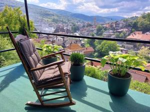 a rocking chair sitting on a balcony with plants at Panorama Travnik in Travnik