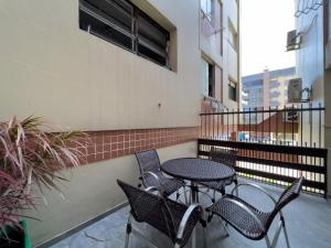 a patio with a table and chairs on a balcony at Vista espetacular beira mar - Capão da Canoa in Capão da Canoa