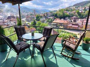 a table and chairs on a balcony with a view at Panorama Travnik in Travnik