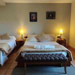 1 dormitorio con 2 camas y 2 lámparas en las mesas en Hostal Tastavins, en Peñarroya de Tastavins