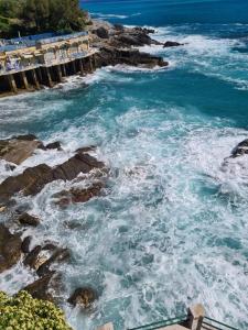 - une vue sur l'océan avec des vagues s'écrasant sur les rochers dans l'établissement Altamarea, à Gênes