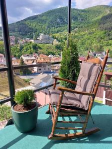 a rocking chair on a balcony with a view at Panorama Travnik in Travnik