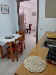 een keuken met een tafel en een wastafel en een tafel en stoelen bij Aggelis House in Sarandë