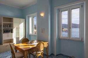 uma sala de jantar com uma mesa e cadeiras e uma janela em La Casina Azzurra Sul Mare em Portoferraio