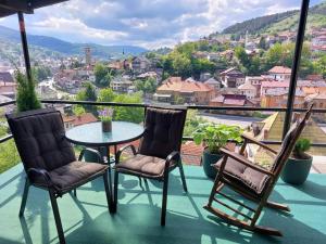 a balcony with a table and two chairs and a view at Panorama Travnik in Travnik