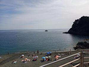 a group of people on a beach with umbrellas at L' eden di Erasmo in Bonassola