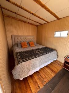 um pequeno quarto com uma cama num quarto em Retiro Bajoestrellas em San Pedro de Atacama