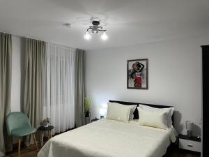 ジェオアジウ・バイにあるCasa Bocanの白いベッドルーム(ベッド1台、青い椅子付)