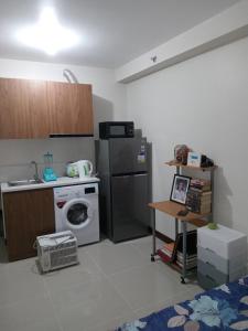 eine Küche mit einer Waschmaschine und einem Kühlschrank in der Unterkunft Haven of Deities Property Rental in Lapu Lapu City