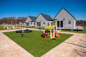 ein Haus mit Spielplatz im Hof in der Unterkunft Saint Wicie in Darłowo