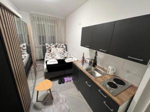 een keuken met een wastafel en een bed in een kamer bij Apartment 2 in Duisburg-Mitte, Altstadt in Duisburg