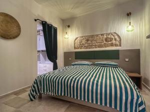 Schlafzimmer mit einem Bett mit gestreifter Decke in der Unterkunft Amay City Suite in Bari