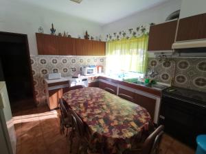 a kitchen with a table and a stove and a sink at Moradia Coelho in Lousã +7 photos