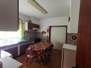 a kitchen with a table and chairs in a room at Moradia Coelho in Lousã