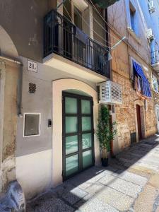 ein Gebäude mit einer grünen Tür und einem Balkon in der Unterkunft Amay City Suite in Bari