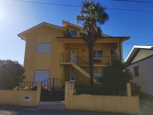 a yellow house with a palm tree in front of it at Moradia Coelho in Lousã