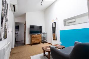 sala de estar con sofá y TV en T2 Toulouse 40m2, Lit Queen Size, Climatisation, quartier sympa, Terrasse en Toulouse
