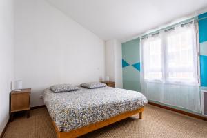 1 dormitorio con cama y ventana en T2 Toulouse 40m2, Lit Queen Size, Climatisation, quartier sympa, Terrasse, en Toulouse