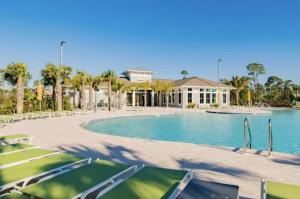 una piscina con sillas y una casa en Summer Breeze at Lost Key Golf & Beach Club, en Pensacola