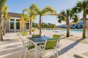 un patio con mesa y sillas junto a una piscina en Summer Breeze at Lost Key Golf & Beach Club, en Pensacola