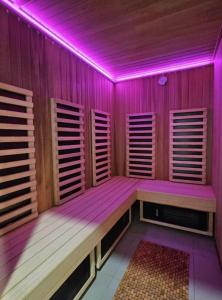 um quarto com luzes roxas num quarto de madeira em Apartament Silence Green Park - Strefa SPA em Szklarska Poręba