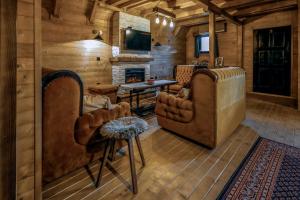 a living room with two chairs and a fireplace at Village house Iva in Livno