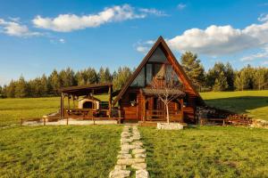 a log cabin in the middle of a field at Village house Iva in Livno