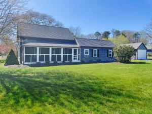 a blue house with a large green yard at 38 Pleasant Street Harwich Port - Pleasant Street Cottage in Harwich Port
