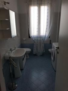 baño con lavabo y aseo y ventana en Sottomarina Beach apartment, en Chioggia