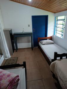um quarto com duas camas e uma mesa em Casa Amarela em Lages