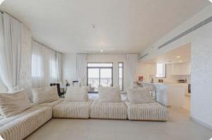 sala de estar con sofá blanco y cocina en PENTHOUSE BURJ AL ARAB FRONT en Dubái