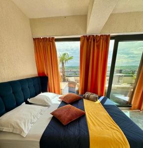 a bed in a room with a large window at PENTHOUSE EXCLUSIVE VIEW , Iasi in Iaşi