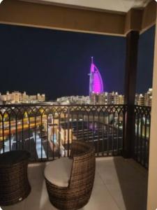 balcón con vistas a la ciudad por la noche en PENTHOUSE BURJ AL ARAB FRONT en Dubái