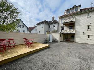 un gruppo di sedie rosse su un patio di fronte a una casa di Ledaal Place 1 by Stavanger BnB a Stavanger