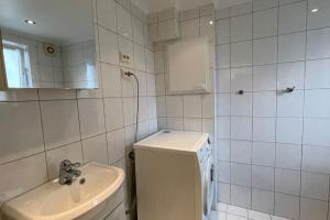 un bagno piastrellato bianco con servizi igienici e lavandino di Ledaal Place 1 by Stavanger BnB a Stavanger