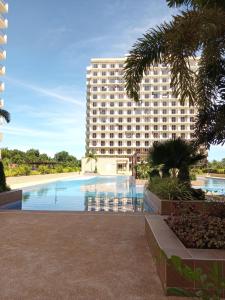 ein Hotel mit einem Pool vor einem Gebäude in der Unterkunft Haven of Deities Property Rental in Lapu Lapu City