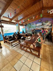 Restauracja z ludźmi siedzącymi przy stolikach i malowidłem w obiekcie Costa Rica Backpackers w San José