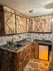 una cocina con armarios de madera y fregadero en Tarihi Mardin evi Hobbit ev en Mardin
