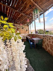 eine Terrasse mit einem Tisch, Stühlen und Blumen in der Unterkunft Tarihi Mardin evi Hobbit ev in Mardin