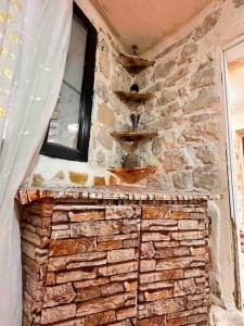 einen gemauerten Kamin mit einer Steinmauer und einem Fenster in der Unterkunft Tarihi Mardin evi Hobbit ev in Mardin