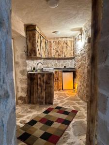 cocina con armarios de madera y suelo a cuadros en Tarihi Mardin evi Hobbit ev en Mardin