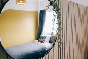 a mirror in a room with a bed and a window at Bee Stays - Long Lane in Warrington