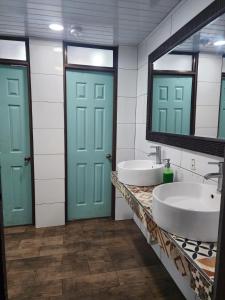 uma casa de banho com dois lavatórios e duas portas azuis em Costa Rica Backpackers em San José