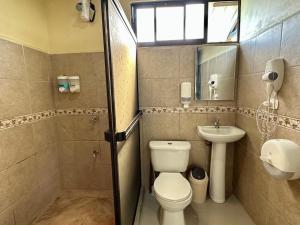 a bathroom with a toilet and a sink at Beautiful View House in Tortuguero