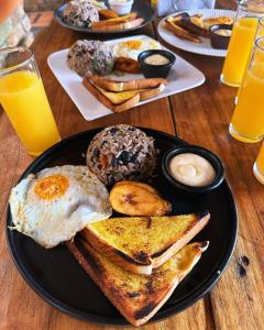 サンホセにあるコスタリカ バックパッカーズの朝食用の食品とドリンクの盛り合わせが備わるテーブル